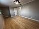 Empty bedroom featuring wood-look floors, large window, and a ceiling fan at 150 Greenbriar Townhouse Way, Las Vegas, NV 89121