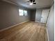 Neutral bedroom with wood-look flooring, white trim, large window, and ceiling fan at 150 Greenbriar Townhouse Way, Las Vegas, NV 89121