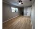 Well-lit bedroom features a large window, ceiling fan, and stylish new wood flooring at 150 Greenbriar Townhouse Way, Las Vegas, NV 89121