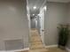 Hallway featuring neutral paint, new light wood-look flooring, and white trim at 150 Greenbriar Townhouse Way, Las Vegas, NV 89121