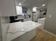 Updated kitchen features white cabinets, stone countertops, and stainless steel appliances at 150 Greenbriar Townhouse Way, Las Vegas, NV 89121