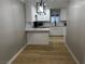 Eat-in kitchen area boasts stylish light fixture, island, white cabinetry, and new flooring at 150 Greenbriar Townhouse Way, Las Vegas, NV 89121