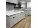 Updated kitchen showcasing stone countertops, stainless steel appliances, and stylish white cabinets at 150 Greenbriar Townhouse Way, Las Vegas, NV 89121