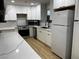 Modern kitchen boasts white cabinets, quartz countertops, stainless appliances, and stylish floors at 150 Greenbriar Townhouse Way, Las Vegas, NV 89121