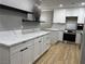Modern kitchen featuring white cabinets, sleek black hardware, stainless steel oven and light countertops at 150 Greenbriar Townhouse Way, Las Vegas, NV 89121