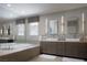 Contemporary bathroom featuring dual sinks, large mirror, and a luxurious soaking tub at 1683 Tangiers Dr, Henderson, NV 89012