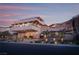 Three-story home with manicured grounds and a mountain view featuring a large driveway and exterior lighting at 1683 Tangiers Dr, Henderson, NV 89012
