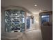 Modern wine room with custom glass shelving and storage, seamlessly integrated into the living space at 1683 Tangiers Dr, Henderson, NV 89012