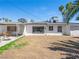 A backyard featuring a covered patio, some grass, and palm trees offers a private outdoor space for relaxation and recreation at 1704 S 8Th St, Las Vegas, NV 89104