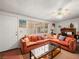 Cozy living room featuring a comfortable orange sofa, coffee table, and a ceiling fan at 1704 S 8Th St, Las Vegas, NV 89104