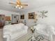 Bright living room featuring white sofas, artwork, and a ceiling fan with decorative lighting at 1704 S 8Th St, Las Vegas, NV 89104