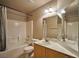 Cozy bathroom features a shower and bathtub combo, toilet, and vanity sink with mirror at 1740 Flores Ln, Henderson, NV 89012