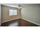 Neutral-painted bedroom with wood floors, window, and ceiling fan at 1740 Flores Ln, Henderson, NV 89012