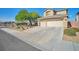 Attractive exterior featuring three-car garage, desert landscaping with trees, and convenient driveway at 1740 Flores Ln, Henderson, NV 89012