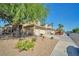 Charming two-story home featuring a desert landscape, mature tree, and secure wrought iron fence at 1740 Flores Ln, Henderson, NV 89012