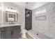 Modern bathroom featuring a shower with black and white marble tiling, and a gray vanity with sink and faucet at 1804 Pacific St, Las Vegas, NV 89104