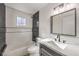 Bathroom featuring black accents in the shower, herringbone patterned tile, and gray vanity at 1804 Pacific St, Las Vegas, NV 89104