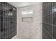 A shower featuring black and white marble tiling, a shower head, and a built in shelf at 1804 Pacific St, Las Vegas, NV 89104