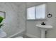 Bathroom featuring a pedestal sink, tiled shower, and marble-look shower surround at 1825 Howard Ave, Las Vegas, NV 89104