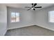 A cozy bedroom with a ceiling fan and windows offering outdoor views and natural light at 1825 Howard Ave, Las Vegas, NV 89104