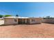 The rear of the home features a gravel backyard, windows and a covered patio at 1825 Howard Ave, Las Vegas, NV 89104