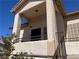 Inviting balcony showcasing stucco columns, overhead lighting, and a dark-toned security door at 1830 N Buffalo Dr # 2022, Las Vegas, NV 89128