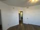 Bright bedroom featuring dark floors, white walls, a bathroom view, and a doorway at 1830 N Buffalo Dr # 2022, Las Vegas, NV 89128