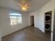 Bright bedroom featuring dark floors, white walls, a window view, and stacked laundry appliances at 1830 N Buffalo Dr # 2022, Las Vegas, NV 89128