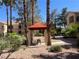 Charming outdoor area featuring mature landscaping, a quaint picnic table, and covered shelter for relaxing or entertaining at 1830 N Buffalo Dr # 2022, Las Vegas, NV 89128