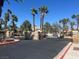 Community entrance with stone pillars, black iron gates and desert landscaping with mature palm trees at 1830 N Buffalo Dr # 2022, Las Vegas, NV 89128