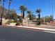 Welcoming community entrance with decorative stone signage, palm trees, and manicured landscaping at 1830 N Buffalo Dr # 2022, Las Vegas, NV 89128