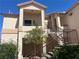Condo building with neutral stucco, a private balcony, and verdant landscaping at 1830 N Buffalo Dr # 2022, Las Vegas, NV 89128