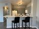 A cozy kitchen featuring gray cabinetry, a white countertop bar with seating, and modern appliances at 1830 N Buffalo Dr # 2022, Las Vegas, NV 89128