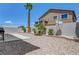 View of the house from the backyard, featuring desert landscaping and a small patio area at 1952 W Hammer Ln, North Las Vegas, NV 89031