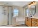Bathroom with soaking tub, shower, and vanity with oak cabinets at 1952 W Hammer Ln, North Las Vegas, NV 89031