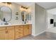 Bathroom with double vanity, wood cabinets, two oval mirrors and modern lighting at 1952 W Hammer Ln, North Las Vegas, NV 89031