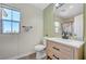 Modern bathroom featuring a sleek vanity, framed mirror, toilet, and natural light from the window at 1952 W Hammer Ln, North Las Vegas, NV 89031