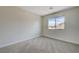 A neutral bedroom boasts natural light from a window overlooking a pleasant neighborhood at 1952 W Hammer Ln, North Las Vegas, NV 89031