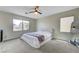 Bright bedroom with a ceiling fan and carpet, featuring a plush bed near a large window at 1952 W Hammer Ln, North Las Vegas, NV 89031