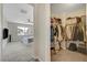 View from Primary bedroom doorway into carpeted closet with hanging clothes and shelving at 1952 W Hammer Ln, North Las Vegas, NV 89031