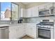 Well-lit kitchen featuring stainless steel appliances and white cabinets with a modern backsplash at 1952 W Hammer Ln, North Las Vegas, NV 89031