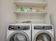 Bright laundry room equipped with white Electrolux washer and dryer and a storage shelf for supplies at 1952 W Hammer Ln, North Las Vegas, NV 89031