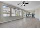 Spacious living area featuring wood-look floors, large windows, and an open layout to the kitchen at 1952 W Hammer Ln, North Las Vegas, NV 89031