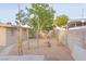 Spacious backyard with gravel, trees, and privacy wall, offering potential for customization at 2001 E Mcwilliams Ave, Las Vegas, NV 89101