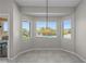 Bright dining area with a modern light fixture, large windows with a pool view, and tile flooring for easy maintenance at 2158 Shubert Ave, Henderson, NV 89052