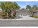Charming single-story home with a landscaped front yard and a two-car garage, nestled under a bright, cloud-dotted sky at 2158 Shubert Ave, Henderson, NV 89052