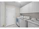 Laundry room features white cabinets, a sink, and a modern washer and dryer at 2158 Shubert Ave, Henderson, NV 89052