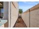 A narrow side yard with desert landscaping and stucco wall, providing privacy at 2158 Shubert Ave, Henderson, NV 89052