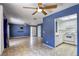 Open living room with tile floors, ceiling fans, and a view into the bright white kitchen at 2349 Wooster Cir # A, Las Vegas, NV 89108