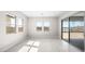 Bright living room with tile flooring, multiple windows offering natural light, and large sliding glass doors to the outside at 237 Paraggi Bay Dr, Henderson, NV 89011